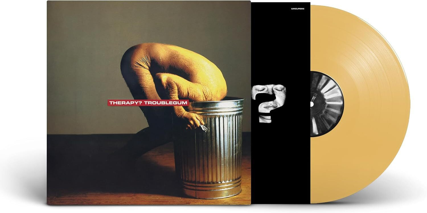 Album cover for "Troublegum" by Therapy?. It depicts a person with a shaved head and bare torso, crouching and bent forward with their head inside a large metal trash can, set against a plain background. The band and album name are in red text at the center.