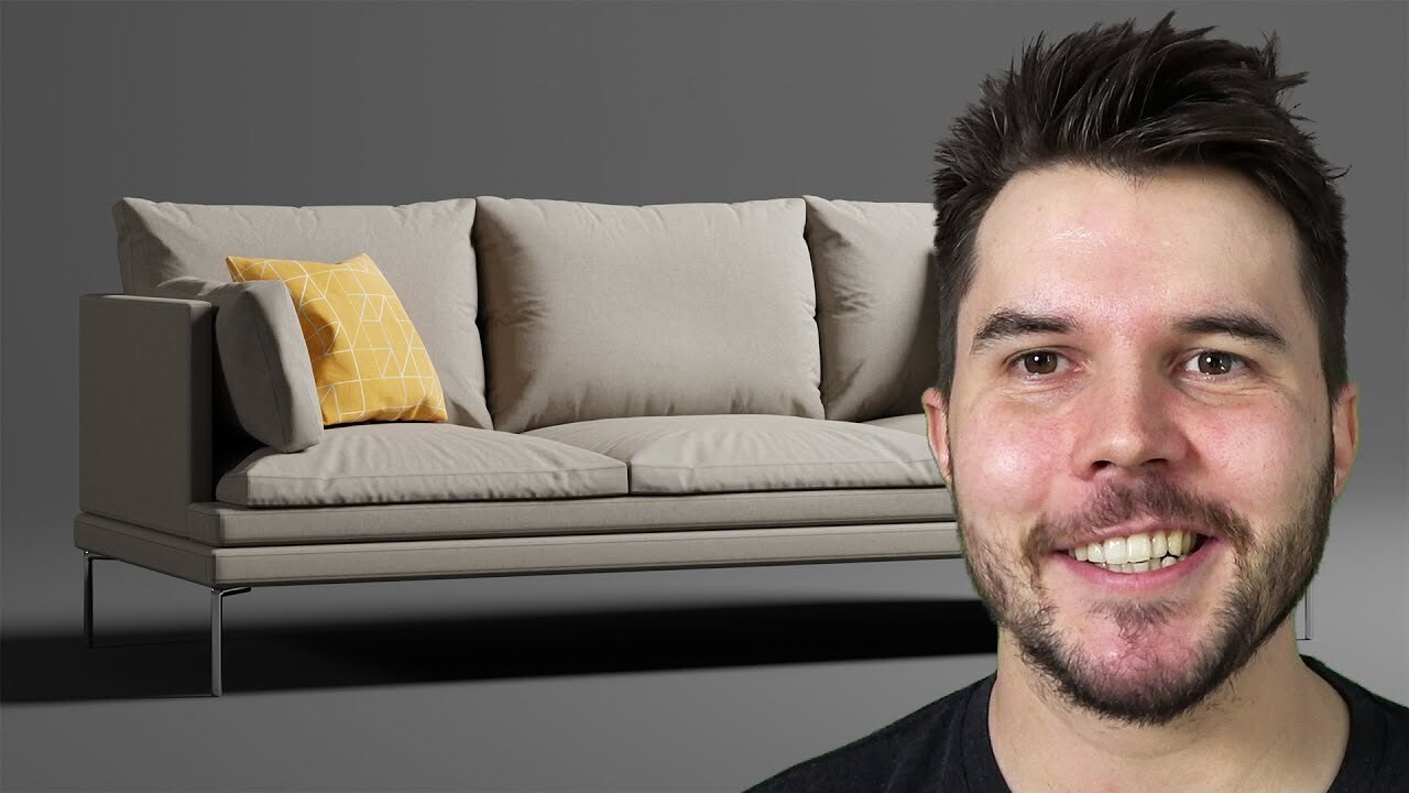 A man with short dark hair and a beard is smiling. Behind him, there is a modern beige sofa with a yellow and white patterned throw pillow on the left side, set against a dark gray background.